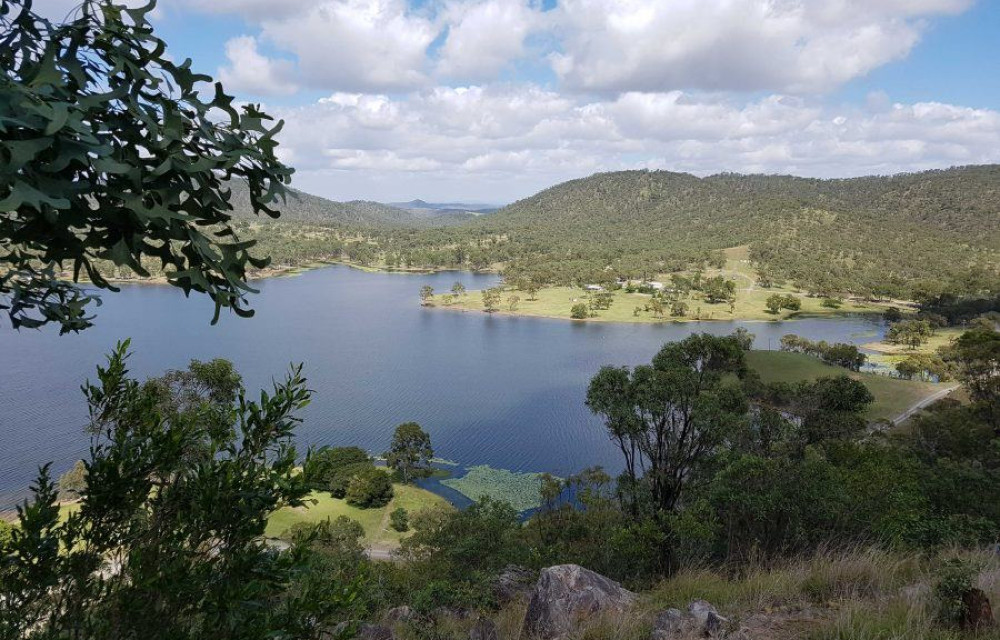 Illustrated rendering of a pumped hydro energy storage facility showing reservoirs, transmission lines, and surrounding Central Queensland landscape